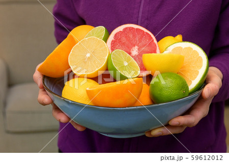 Woman Holding Assorted Citrus Fruit 59612012