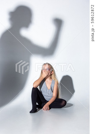 Sad and frightened little girl with bloodshot and bruised eyes sitting scared Sad and frightened little girl with bloodshot and bruised eyes sitting scared 59612872