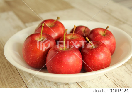 白皿に載った７個の姫りんごの写真素材