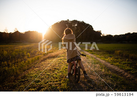 夕焼けの小道を進む自転車に乗った女の子 夕焼けの小道を進む自転車に乗った女の子 59613194