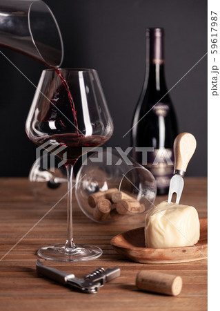 Pouring red wine in crystal glass, bottle, corkscrew, opener, sommelier knife, transparent decanter 59617987