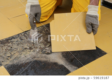 Old vinyl tiles removal from floor in a room or Old vinyl tiles removal from floor in a room or 59619187