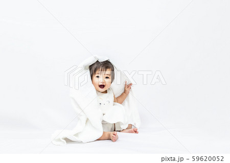 白背景でバスタオルを被りカメラ目線で微笑む女の子の赤ちゃん 白背景でバスタオルを被りカメラ目線で微笑む女の子の赤ちゃん 59620052