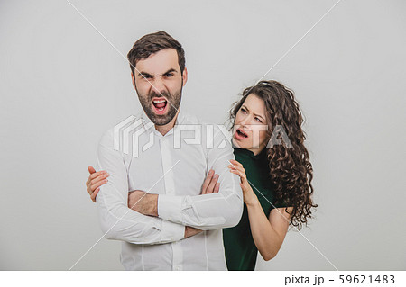Strange photo of foolish man, making faces and woman looking at him, confused. Strange photo of foolish man, making faces and woman looking at him, confused. 59621483