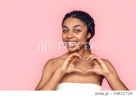 Beauty Concept. Young african woman isolated on pink showing heart shape smiling cheerful 59622729