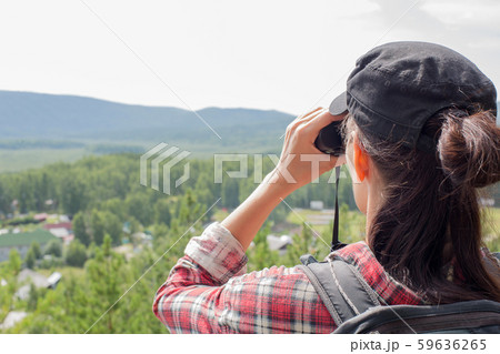 Hiker using binoculars and looking at nature, lake, mountain and trees in summer, close up Hiker using binoculars and looking at nature, lake, mountain and trees in summer, close up 59636265