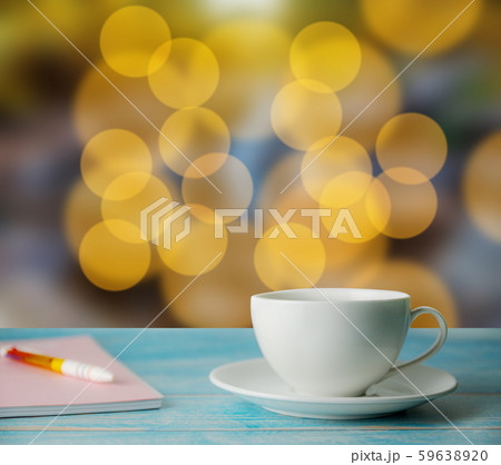 A cup of coffee and notrbook with abstract bokeh A cup of coffee and notrbook with abstract bokeh 59638920