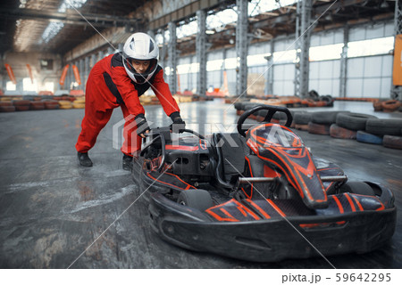 Racer in helmet pushing a go kart car, karting 59642295