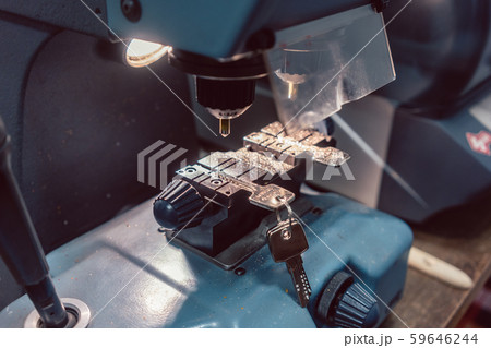 Locksmith cutting key with his machine 59646244