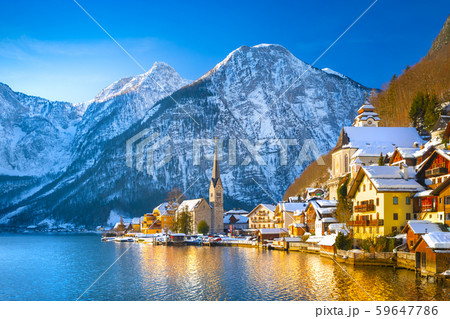 Classic postcard view of famous Hallstatt lakeside town in the Alps with traditional passenger ship on a beautiful cold sunny day with blue sky and clouds in winter, Salzkammergut region, Austria Classic postcard view of famous Hallstatt lakeside town in the Alps with traditional passenger ship on a beautiful cold sunny day with blue sky and clouds in winter, Salzkammergut region, Austria 59647786