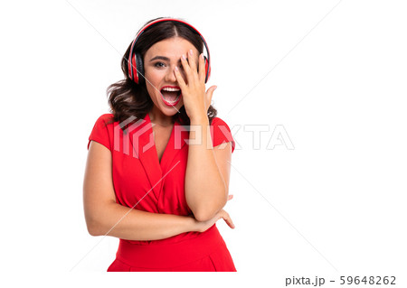A young woman with red lips listens to music in headphones and screams 59648262