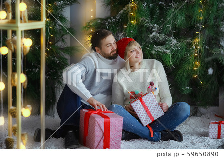 A man with a woman in a photo Studio on the background of an artificial Christmas tree and snow 59650890