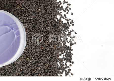 Purple skincare cream in jar with babchi (Psoralea Corylifolia) seed extract on babchi seeds. Copy space, flat lay, isolated. Bakuchiol - retinol alternative concept. 59653689