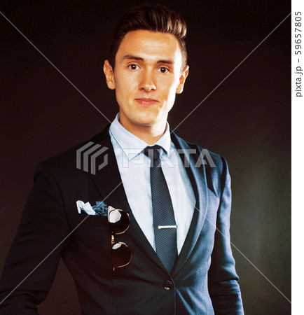 young pretty business man standing on black background, modern hairstyle, talking on phone emotional 59657805