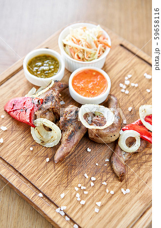 Lamb tongue kebab with Pickled cabbage and two sauces. Serving on a wooden Board. Barbecue Lamb tongue kebab with Pickled cabbage and two sauces. Serving on a wooden Board. Barbecue 59658116