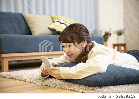 女性　ニット　寝転ぶ　スマホ　スマートフォン　携帯　携帯電話 59659218
