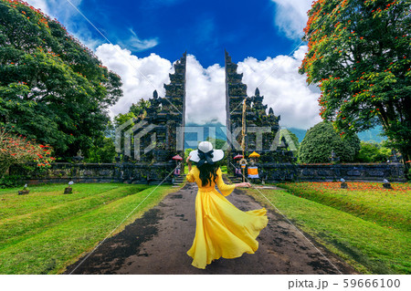 Woman walking at big entrance gate, Bali Woman walking at big entrance gate, Bali 59666100
