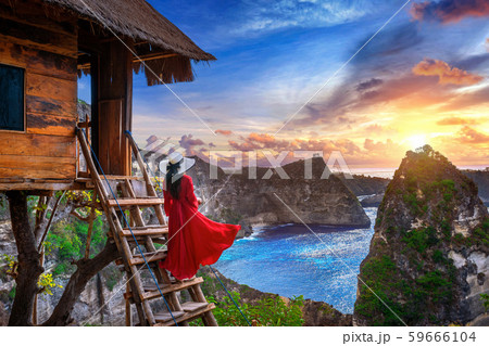 Young girl on steps of house on tree at sunrise  59666104
