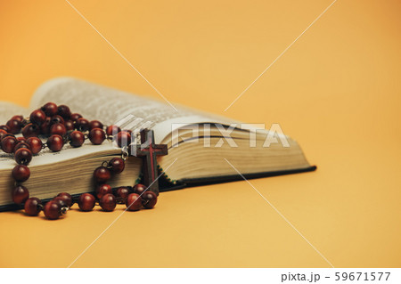 Open Holy Bible with old beads on a yellow 59671577