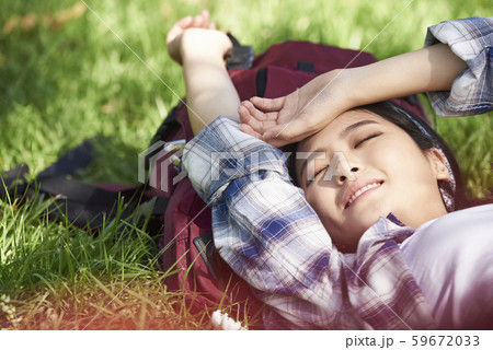 女性　芝生に寝転がる 59672033