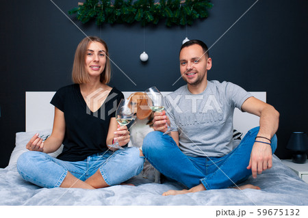 Young couple sitting on a bed in the bedroom, 59675132