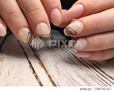 Gray striped nail design on female hand close up. Gray striped nail design on female hand close up. 59676107
