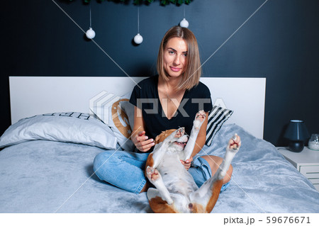 Young beautiful woman playing with dog sitting on Young beautiful woman playing with dog sitting on 59676671