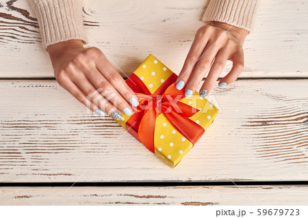 Female fingers with a manicure tie a bow. Female fingers with a manicure tie a bow. 59679723