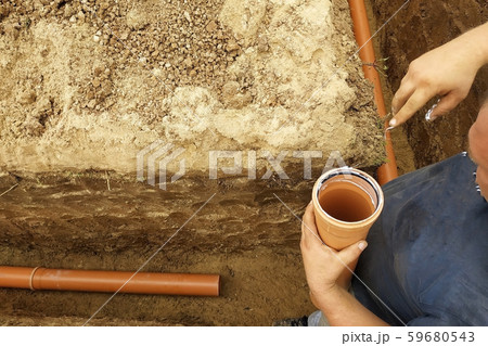 The employee connects the sewer pipes and connects The employee connects the sewer pipes and connects 59680543
