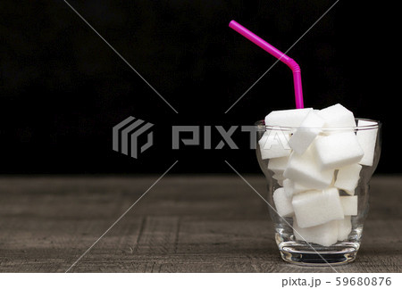 glass filled with pieces of white sugar, a glass filled with pieces of white sugar, a 59680876