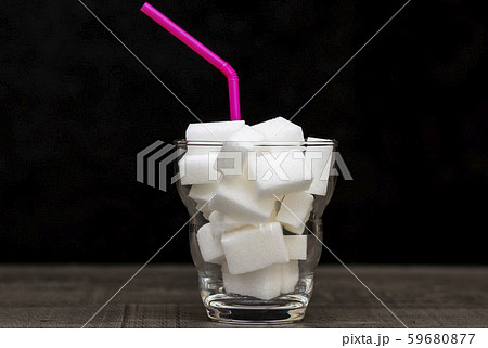 glass filled with pieces of white sugar, a glass filled with pieces of white sugar, a 59680877