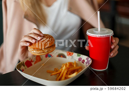 Young woman eats fast food Young woman eats fast food 59684202