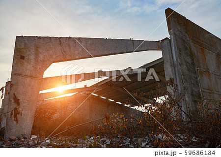 Concrete beams and walls of the destroyed old warehouse in the rays of the rising sun Concrete beams and walls of the destroyed old warehouse in the rays of the rising sun 59686184
