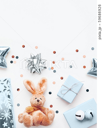 Holiday presents in shadows of blue and silver - fluffy toy rabbit, gifts with decorative bells, sparkling confetti, stars. Presents for little boy. Holiday presents in shadows of blue and silver - fluffy toy rabbit, gifts with decorative bells, sparkling confetti, stars. Presents for little boy. 59686926