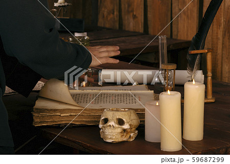 The medieval mage leaned on a spell book. Part of the body.Witchcraft The medieval mage leaned on a spell book. Part of the body.Witchcraft 59687299