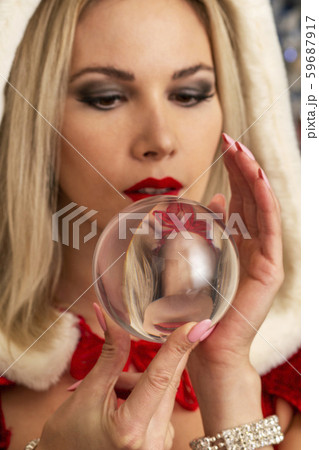 beautiful girl in a Christmas costume holds a mysterious, magic glass ball in her hands beautiful girl in a Christmas costume holds a mysterious, magic glass ball in her hands 59687917