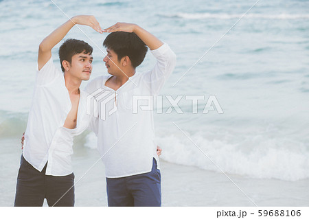 Homosexual portrait young asian couple stand gesture heart shape together on beach in summer Homosexual portrait young asian couple stand gesture heart shape together on beach in summer 59688106