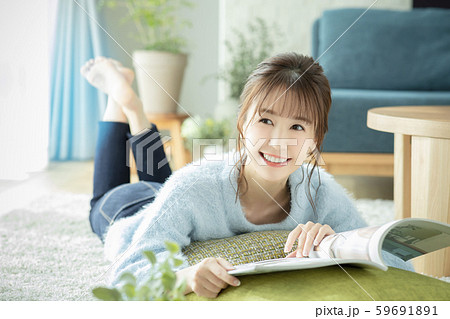 女性　リビング　部屋　雑誌　本　読む　うつ伏せ 59691891