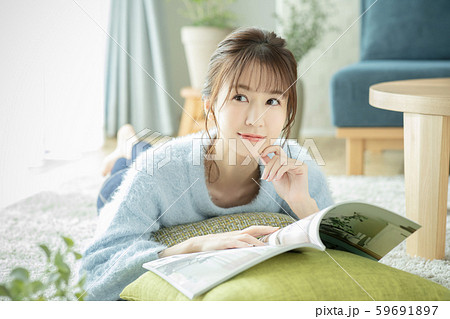 女性　リビング　部屋　雑誌　本　読む　うつ伏せ 59691897