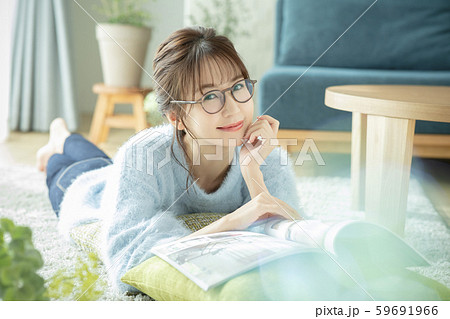 女性　リビング　部屋　雑誌　本　読む　うつ伏せ 59691966