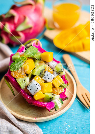 Mix tropical fruits salad served in half a dragon Mix tropical fruits salad served in half a dragon 59693823