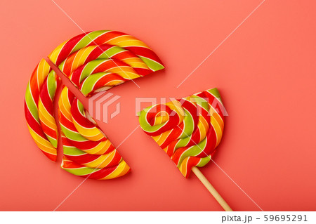 Lollipop broken into pieces on pink background, Lollipop broken into pieces on pink background, 59695291