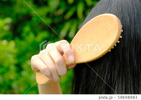 Woman brushing her long straight natural black hair Woman brushing her long straight natural black hair 59698983