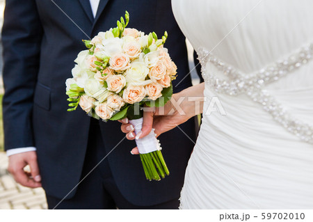 Beautiful wedding bouquet in hands of the bride Beautiful wedding bouquet in hands of the bride 59702010