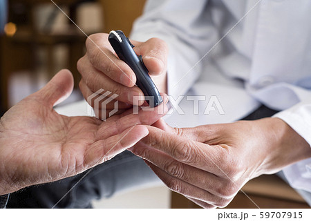 measuring the blood glucose level of an old man measuring the blood glucose level of an old man 59707915