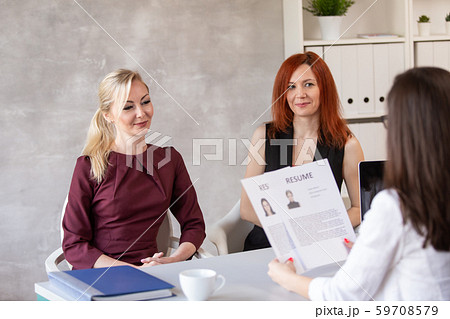 HR and her assistant talk with potential employee and discuss her resume. Selective focus 59708579