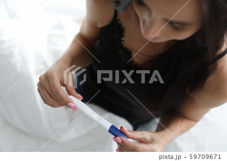 Woman holding pregnancy test results Woman holding pregnancy test results 59709671