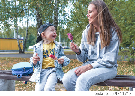 Happy family, sitting bench, mother woman with little boy son 4-5 years old, eat ice cream, support Happy family, sitting bench, mother woman with little boy son 4-5 years old, eat ice cream, support 59711717