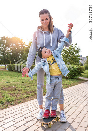 Young mother woman with little boy son of 4-5 years old, Support help balance training. Emotions of Young mother woman with little boy son of 4-5 years old, Support help balance training. Emotions of 59711754