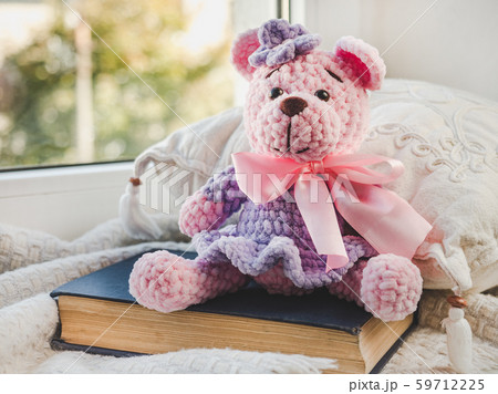 Bright plush toy sitting on a windowsill Bright plush toy sitting on a windowsill 59712225